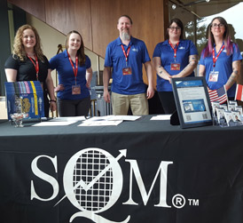 Five SQM Staff wearing blue shirts at a conference table